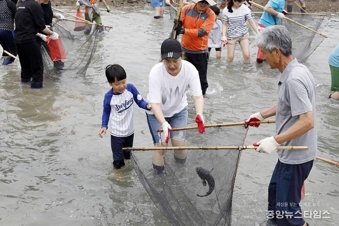 뱃놀이 축제에서 전통 물고기 잡기 체험을 하고 있는 모습