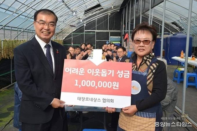정영기 태장르네상스협의회장이 25일 1년 동안 땀과 열정으로 직접 키운 다양한 국화 작품들을 전시하고 판매한 수익금 100만원을 이웃돕기 성금으로 송영완 영통구청장에 기탁했다.(사진=영통구청)