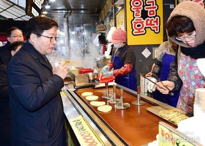 염태영 수원시장이 지역상권을 살리기 위해 못골시장에서 직접 장을 보며 간식거리를 구매하고 있다. (사진=수원시)