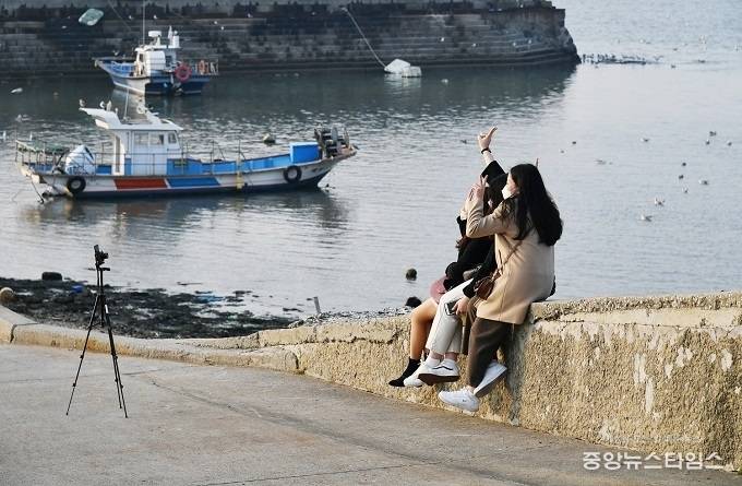 10월 27일 오이도로 함께 놀러나온 친구들이 바다를 배경으로 사진을 찍고 있다.