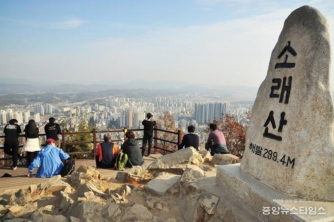 소래산 정상표지석. 시민들이 정상에서 시흥시 전경을 내려다보고 있다.