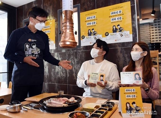 오비맥주 임직원이 본사 인근 주류 판매 업소에서 주류를 주문한 고객들의 신분증 확인을 독려하는 ‘귀하 신분’ 캠페인을 펼치고 있다.(오비맥주 제공)
