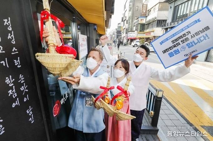 한복을 입은 오비맥주 배하준 대표(왼쪽)와 직원들이 강남구 삼성동 인근 음식점 입구에서 복조리를 달고 있다. / 사진=오비맥주 제공