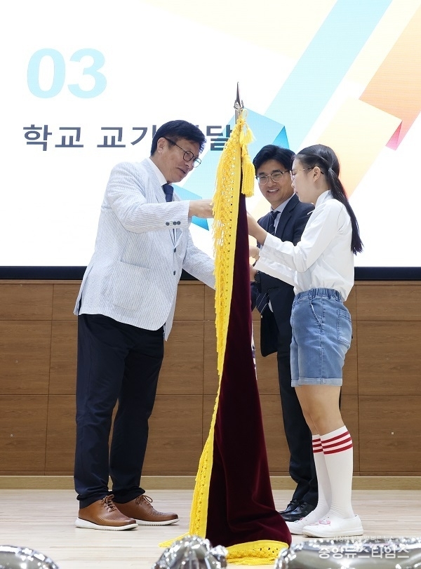 도성훈 인천시교육감이 20일 열린 인천아람초등학교 개교기념식에서 정봉남 교장과 김예원(6학년)학생에게 교기를 전달하고 있다.
