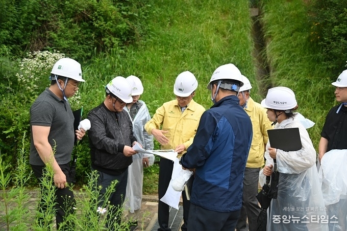 화성 함백산추모공원에서 김근영 사장(가운데 노란옷)과 안전관리 부서 임직원들이 배수로 설계도면을 확인하며 강우 피해 방지 대책을 세우고 있다.(화성도시공사 제공)