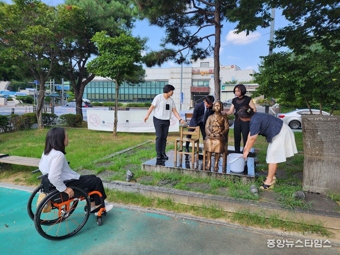 평화의소녀상을 청소하고 있다.(사진=최승혁 안성시의원)