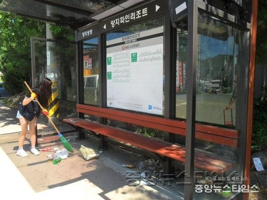 자원봉사에 참여한 한 청소년이 버스정류장을 치우는 모습.JPG