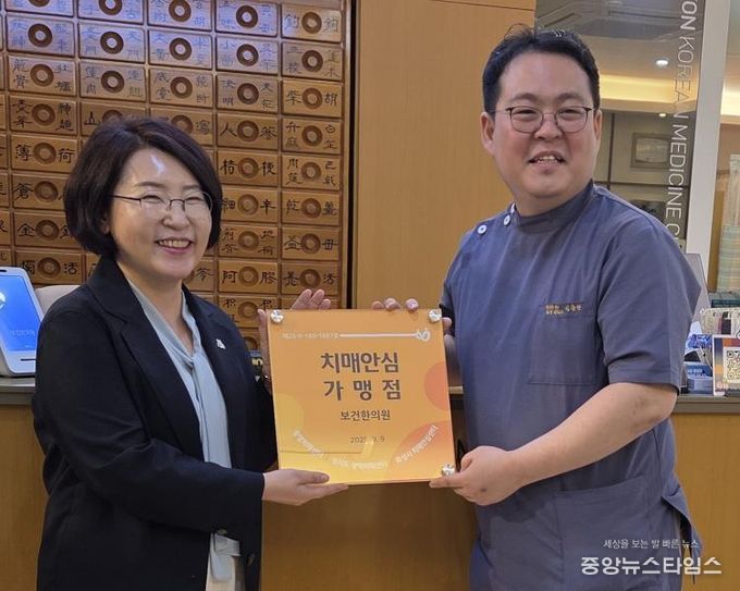 화성특례시가 22일 신규 치매안심가맹점으로 지정된 보건한의원에 현판을 전달하고 있다.(화성시 제공)