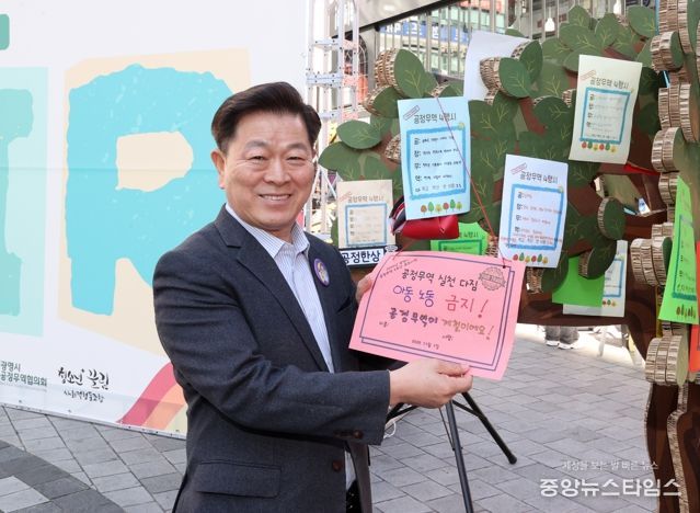 박승원 광명시장이 지난 1일 철산상업지구 원형광장에서 열린 ‘2025 공정무역 2주간 캠페인-포트나잇’의 당일 캠페인에 참석해 공정무역 소비 실천을 다짐하는 서약문을 들고 기념사진을 촬영하고 있다.