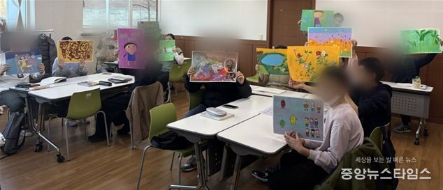 인천장애인종합복지관과 혜원의료재단이 협업한 장애인 예술일자리사업에 참여하는 장애인들이 작품을 들고 기념 촬영을 하고 있다,