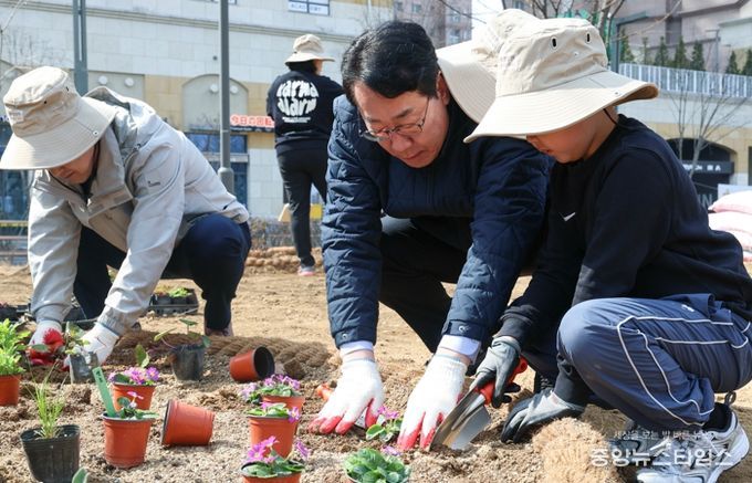 정명근 화성특례시장(가운데)이 21일 동탄여울공원에서 화성특별정원에 아이와 함께 꽃을 심고 있다.(화성시 제공)